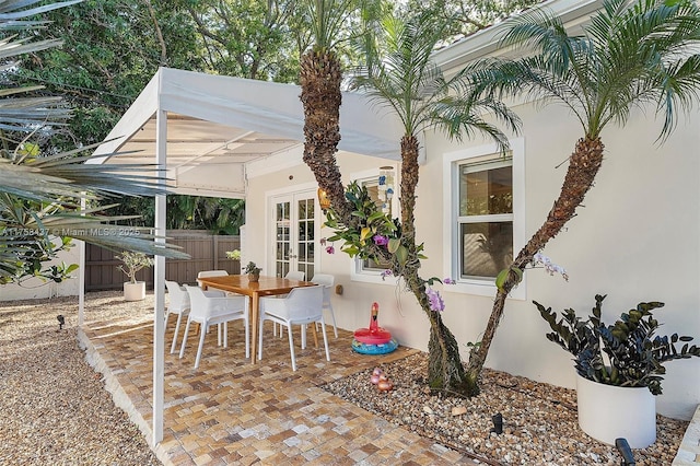 view of patio / terrace with french doors, fence, and outdoor dining area