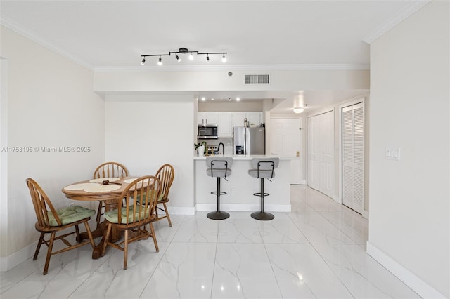 2665 SW 37th Ave Unit 612, Miami, FL 33133 - dining space featuring light marble finish flooring, baseboards, and ornamental molding
