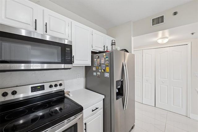 2665 SW 37th Ave Unit 612, Miami, FL 33133 - kitchen with appliances with stainless steel finishes, white cabinets, light countertops, and light marble finish flooring