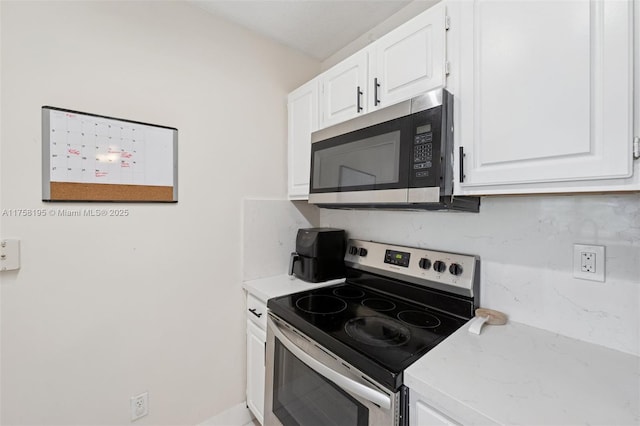 2665 SW 37th Ave Unit 612, Miami, FL 33133 - kitchen with stainless steel appliances, white cabinets, and backsplash