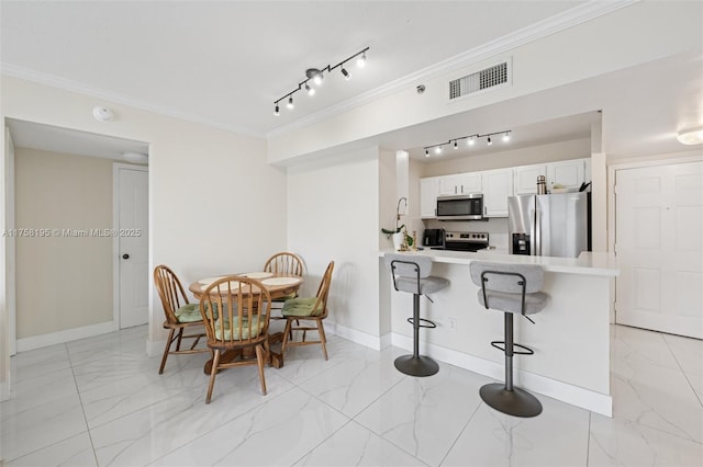 2665 SW 37th Ave Unit 612, Miami, FL 33133 - dining room featuring light marble finish floors, ornamental molding, baseboards, and track lighting