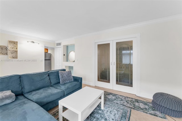 tiled living area with french doors, visible vents, crown molding, and baseboards