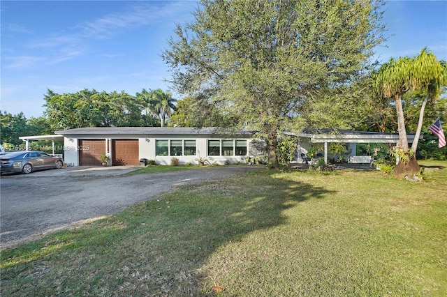 view of front of house featuring driveway, a front lawn, and an attached garage