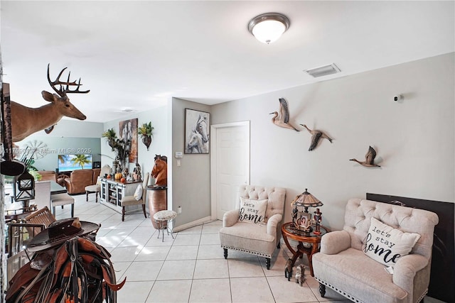 living room with visible vents, baseboards, and light tile patterned floors