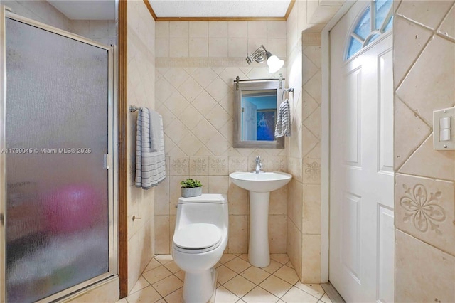 bathroom with ornamental molding, tile walls, a shower stall, and tile patterned floors