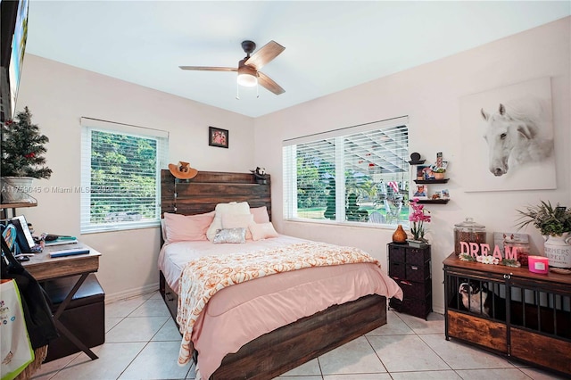 bedroom featuring light tile patterned floors, a ceiling fan, and baseboards