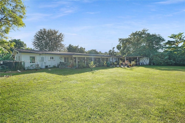 view of yard with an outbuilding, a sunroom, and a shed