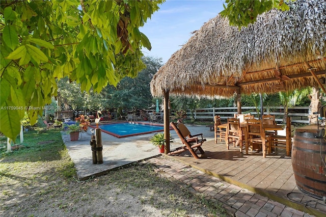 pool featuring a patio area, outdoor dining area, and a gazebo