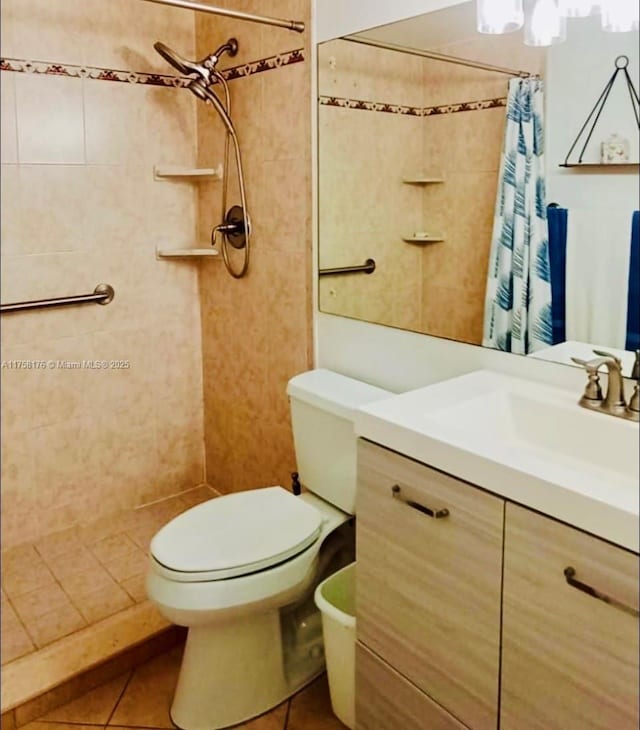 full bath with vanity, a tile shower, toilet, and tile patterned floors