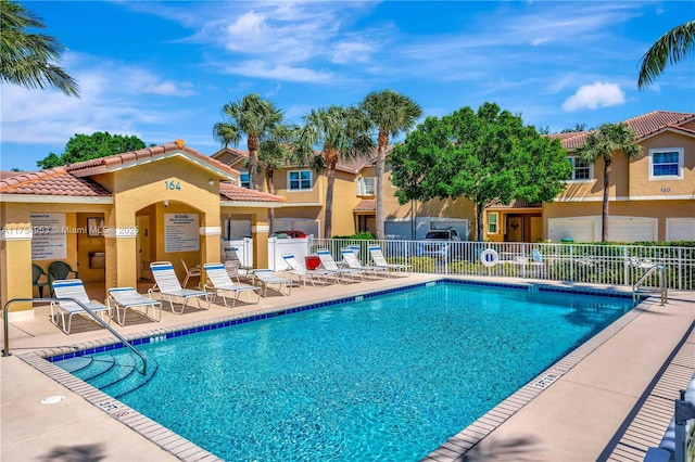 pool featuring a residential view, a patio area, and fence