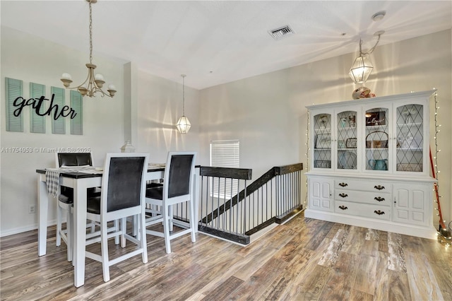 dining space featuring a notable chandelier, visible vents, and wood finished floors