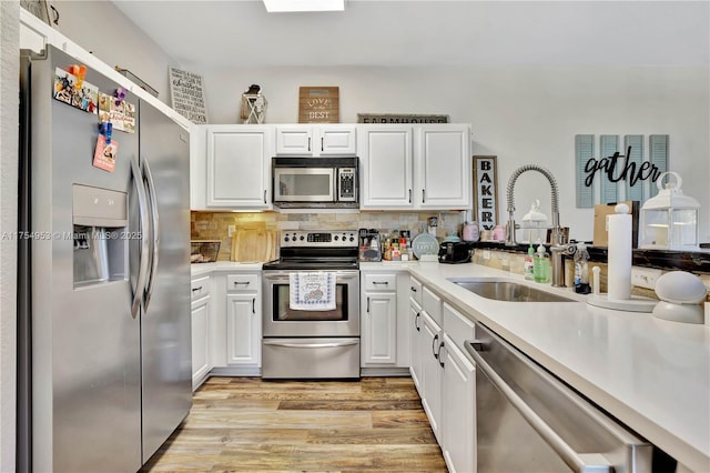 kitchen with white cabinetry, stainless steel appliances, and a sink