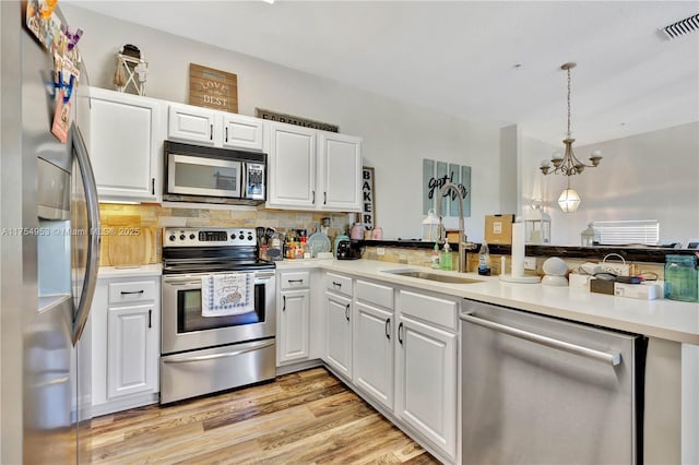 kitchen with white cabinets, stainless steel appliances, visible vents, and light wood-style floors