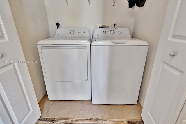 laundry room featuring light tile patterned floors, laundry area, and washing machine and dryer