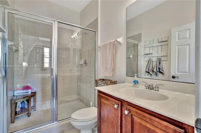 bathroom featuring a shower stall, toilet, and vanity