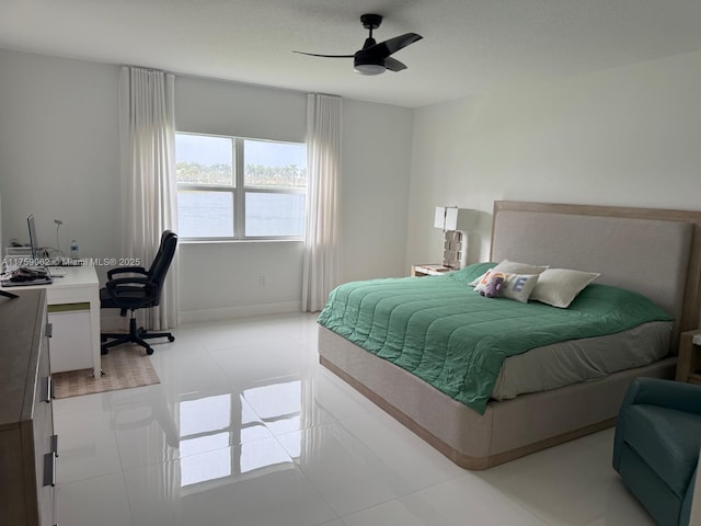 bedroom featuring a water view, ceiling fan, and baseboards