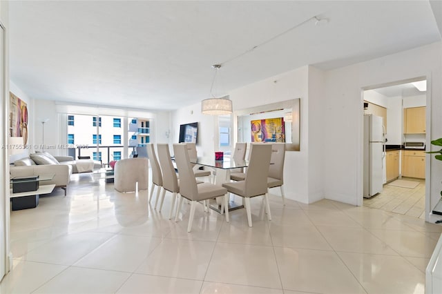 dining room with a wall of windows, plenty of natural light, baseboards, and light tile patterned floors