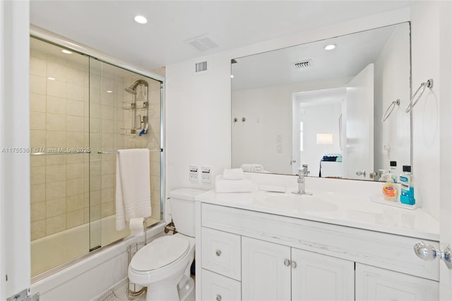 full bathroom featuring toilet, shower / bath combination with glass door, visible vents, and vanity