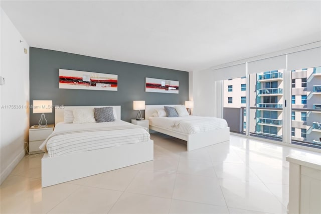 bedroom with baseboards, a wall of windows, and tile patterned floors