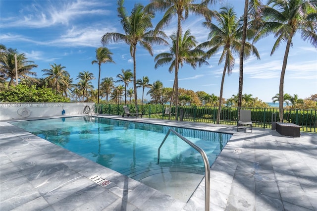 pool with a patio and fence