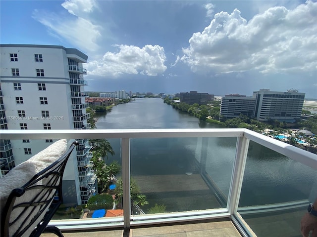 balcony featuring a water view and a city view