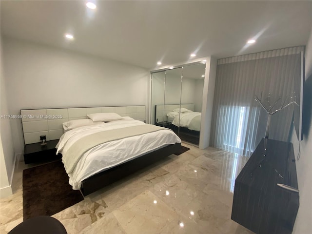 bedroom featuring marble finish floor, a closet, and recessed lighting