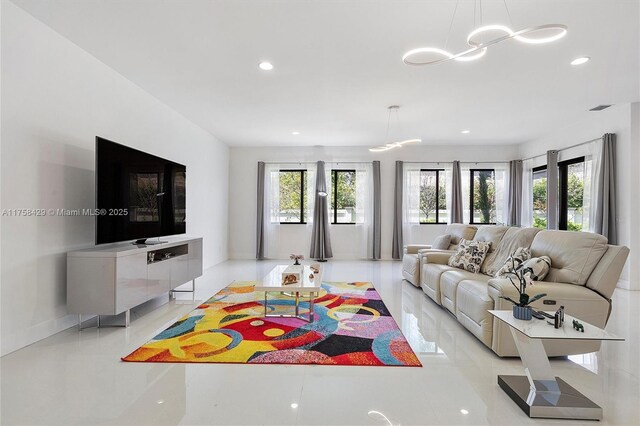 living area featuring a wealth of natural light, a notable chandelier, and recessed lighting