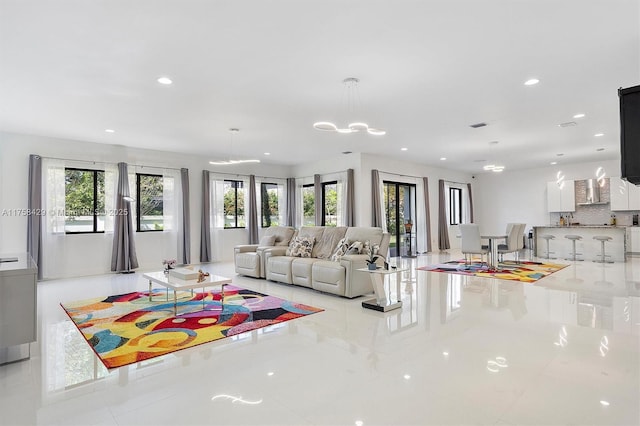 living room with an inviting chandelier, visible vents, a healthy amount of sunlight, and recessed lighting
