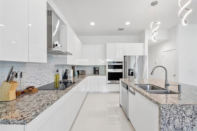 kitchen featuring stainless steel appliances, visible vents, a sink, wall chimney range hood, and modern cabinets