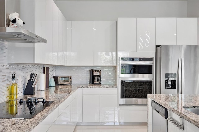 kitchen featuring stainless steel appliances, range hood, white cabinets, and decorative backsplash