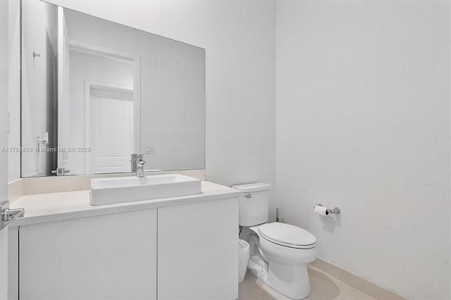 half bath with tile patterned flooring, vanity, and toilet