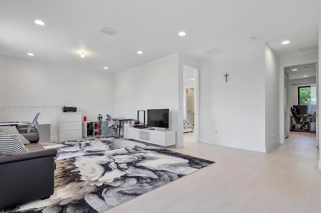 living area with light wood-type flooring, recessed lighting, visible vents, and baseboards