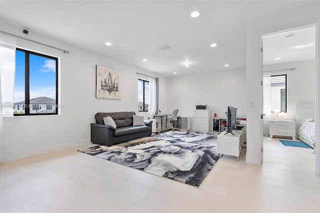 living room featuring baseboards, visible vents, and recessed lighting