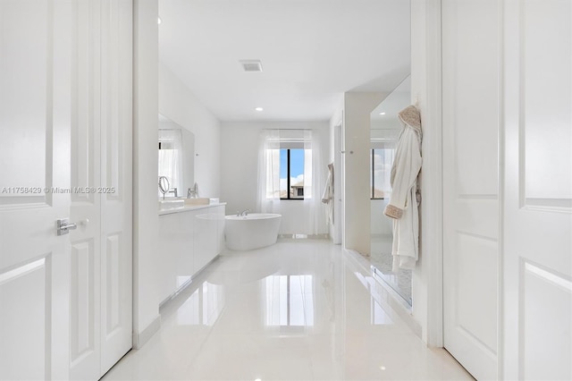 full bath featuring a soaking tub, visible vents, and vanity