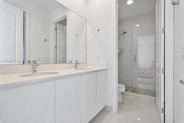 bathroom with toilet, a sink, double vanity, and a shower stall
