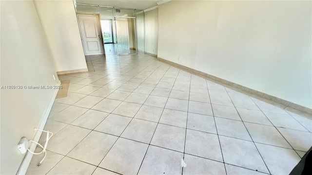 spare room with light tile patterned flooring and baseboards