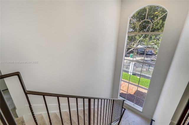 stairway with a healthy amount of sunlight and baseboards