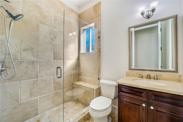 bathroom with toilet, a shower stall, and vanity