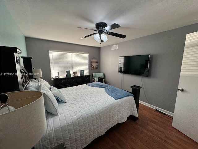 bedroom with visible vents, ceiling fan, baseboards, and wood finished floors