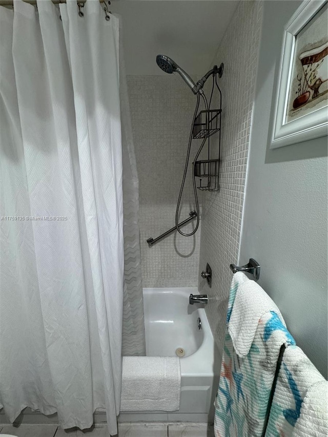 full bathroom with shower / bath combo with shower curtain and a textured wall