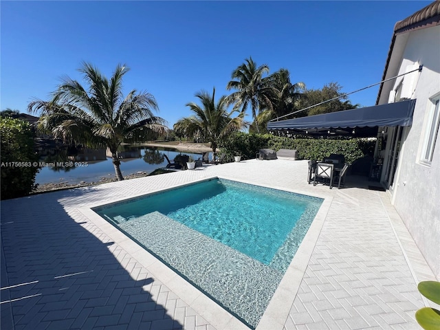 pool featuring a patio and a water view