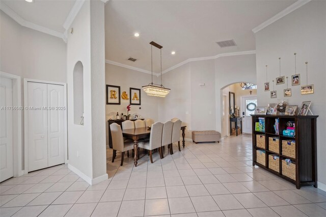 dining area with arched walkways, french doors, crown molding, light tile patterned floors, and ceiling fan with notable chandelier