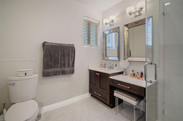 bathroom with marble finish floor, toilet, vanity, a shower stall, and baseboards