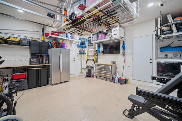 garage featuring freestanding refrigerator and visible vents