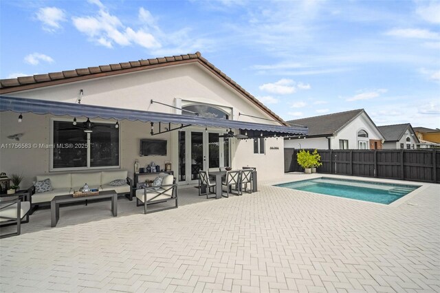 back of house with a fenced in pool, french doors, a patio, stucco siding, and an outdoor living space