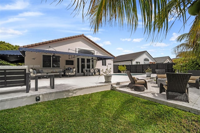 back of house with stucco siding, a fenced backyard, a patio, and an outdoor hangout area