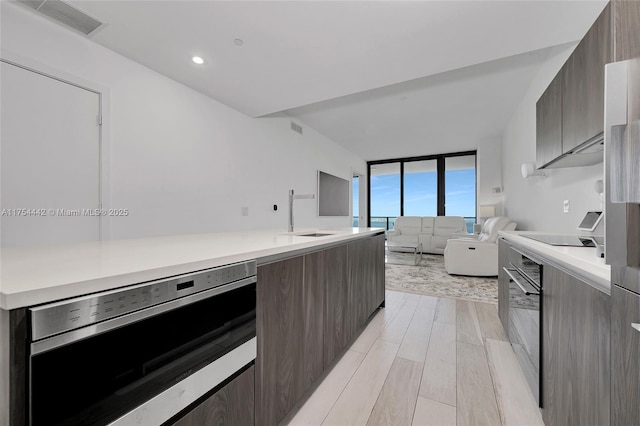 kitchen with modern cabinets, visible vents, light countertops, and open floor plan