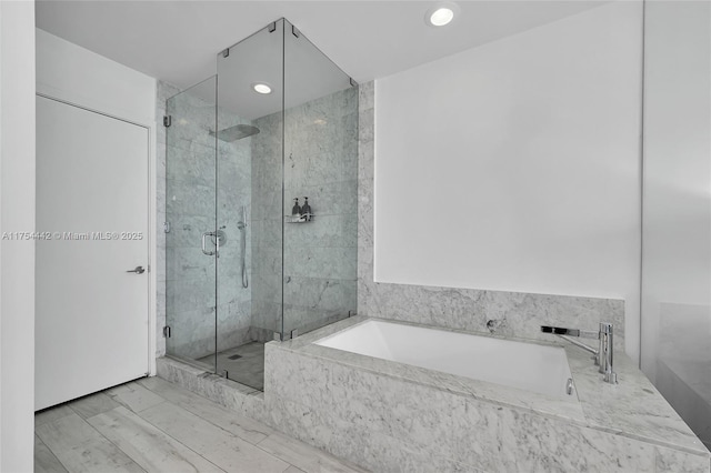 bathroom with a garden tub, a shower stall, and recessed lighting