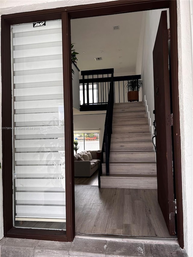 stairway featuring visible vents and wood finished floors