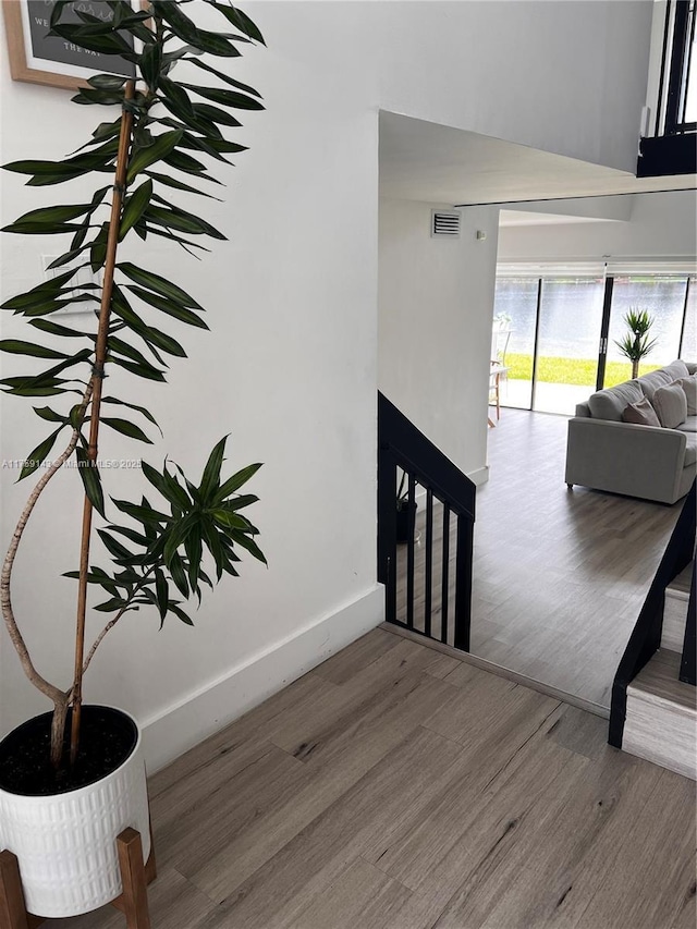 stairway with visible vents, a fireplace, baseboards, and wood finished floors